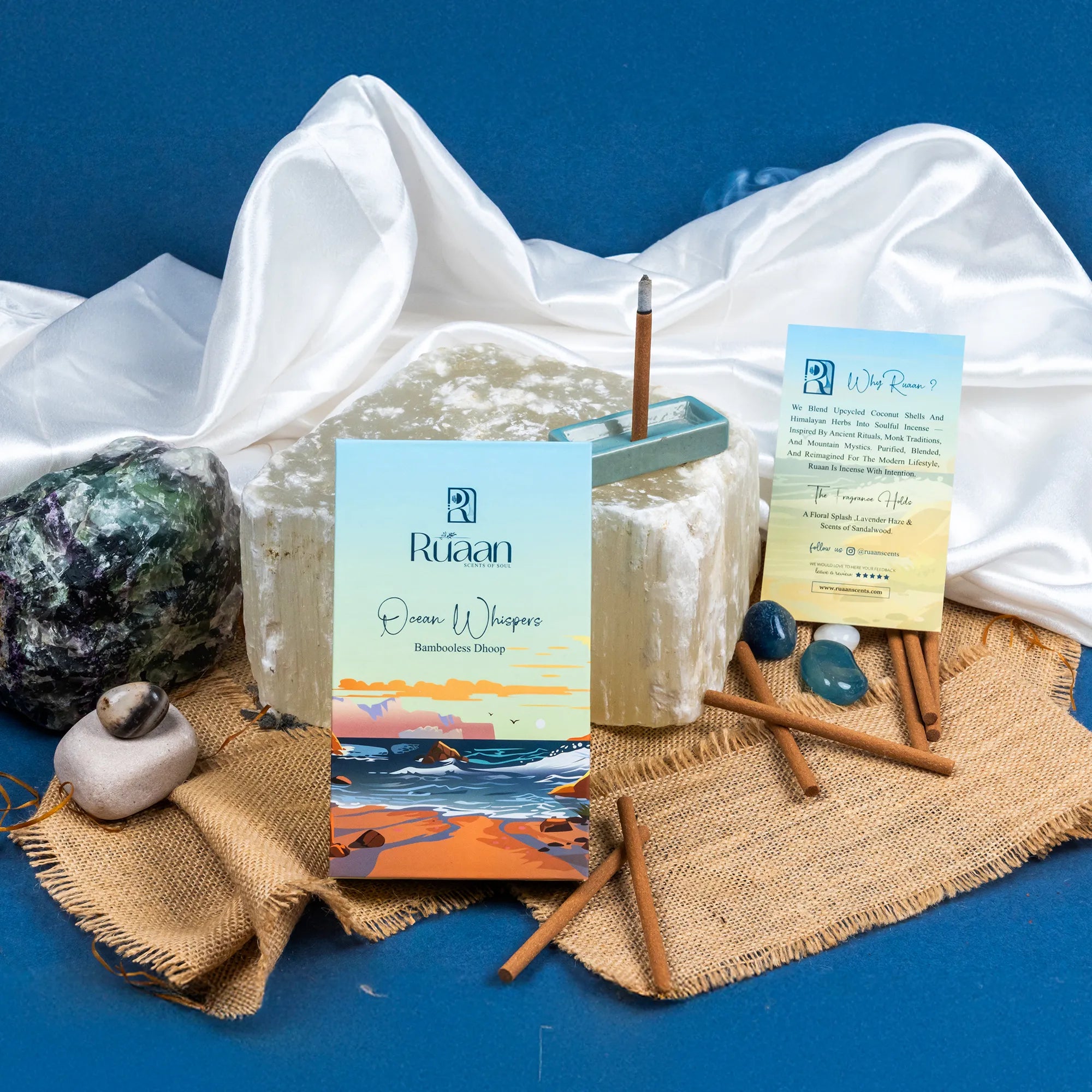 Candle with packaging and decorative items on a blue background